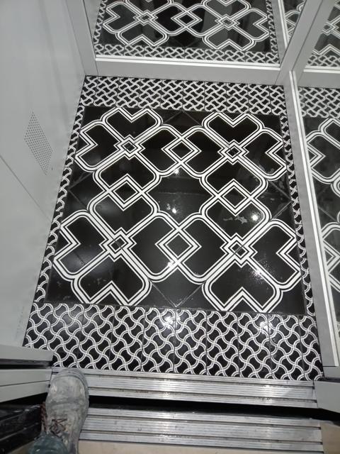 Pavimento decorativo in piastrelle bianche e nere con bordo a scaglie